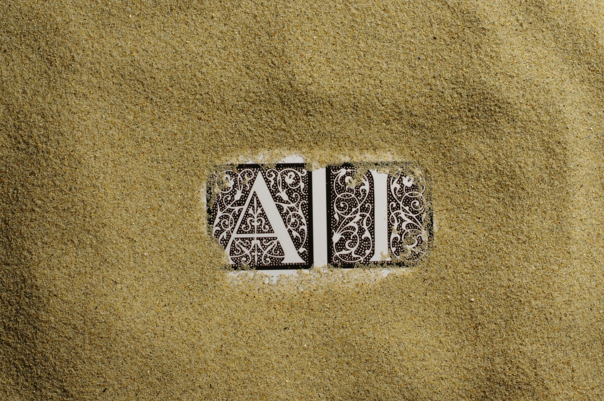 Ai written in tiles covered in sand